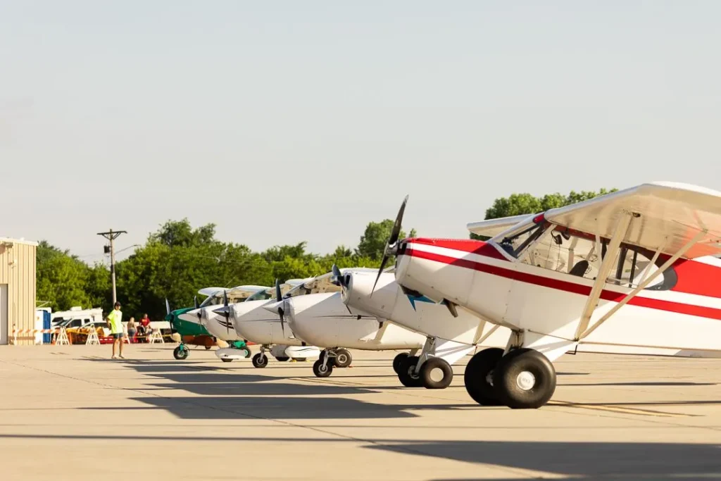 Several small propeller planes lined up on the tarmac.