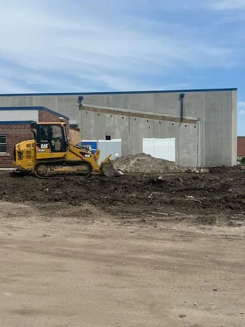 A bulldozer moving dirt around by the new addition.