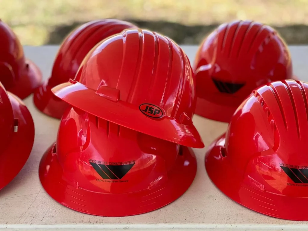 Closeup of red hard hats with the Woodruff Construction logo.