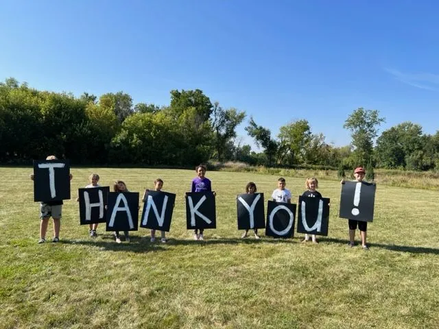 Kids holding up signs with individual letters spelling 'THANK YOU!'